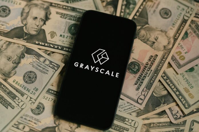 Grayscale Logo auf Smartphone, das auf Dollarscheinen liegt