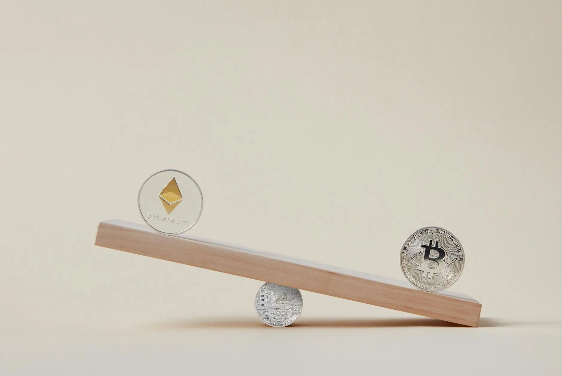 A wooden plank balancing Ethereum and Bitcoin coins on either end.