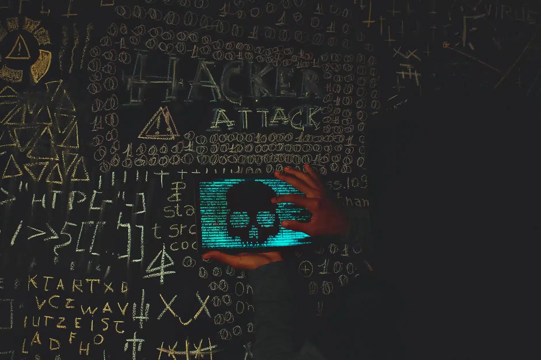 Hands holding a tablet displaying a skull overlaid with code, surrounded by security symbols.