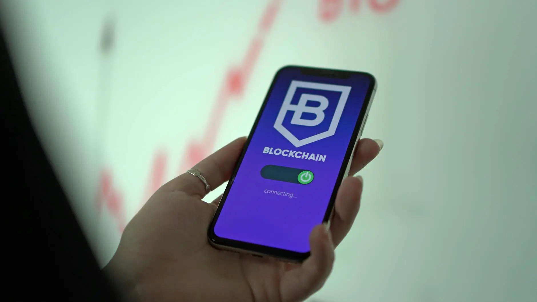 Smartphone displaying a blockchain app with a connecting message.
