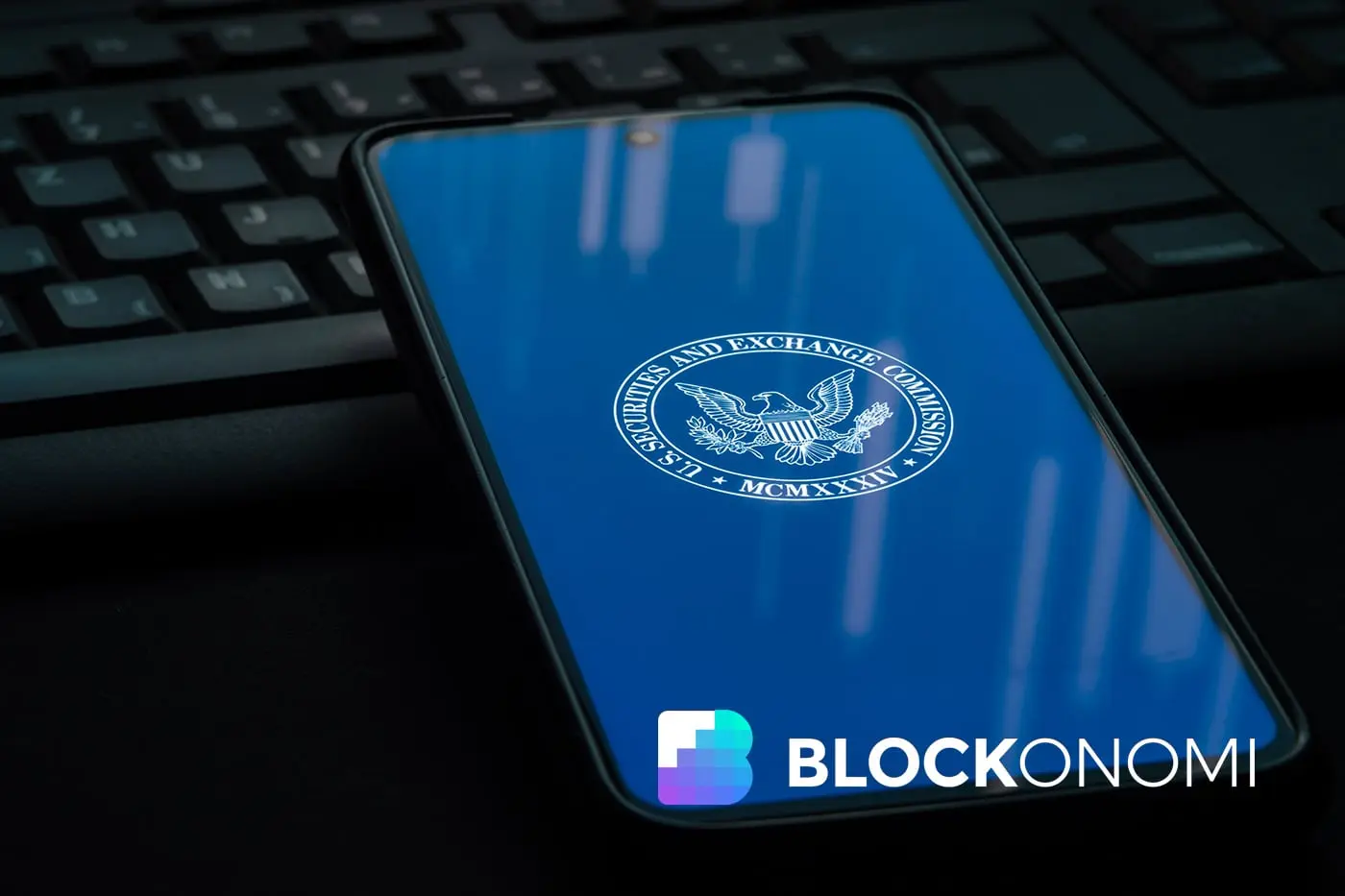 Mobile phone displaying the SEC logo on a blue background near a keyboard.