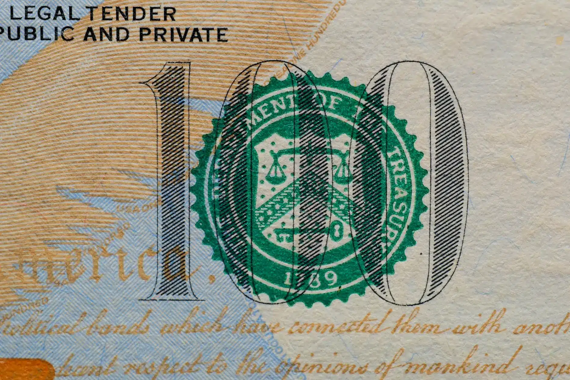 Close-up of a U.S. $100 bill featuring the Treasury seal.