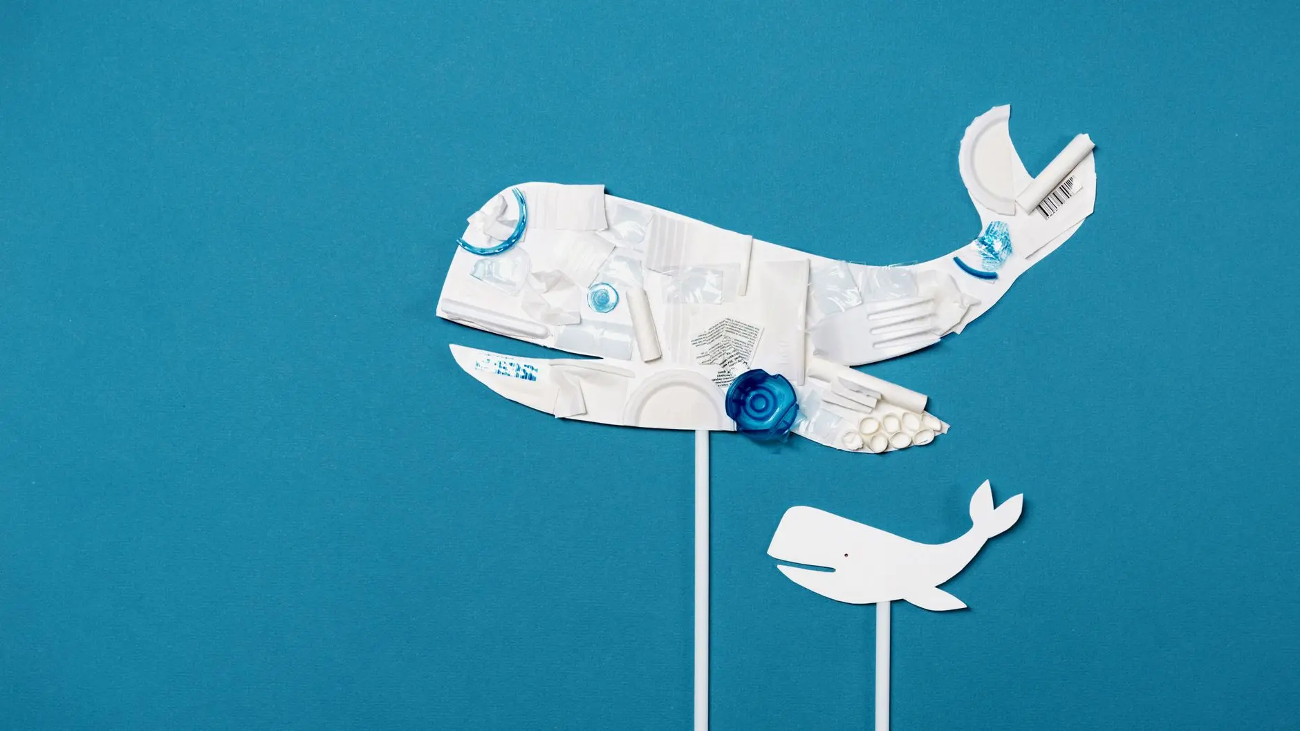 Artistic whale made from plastic pieces on a blue background.