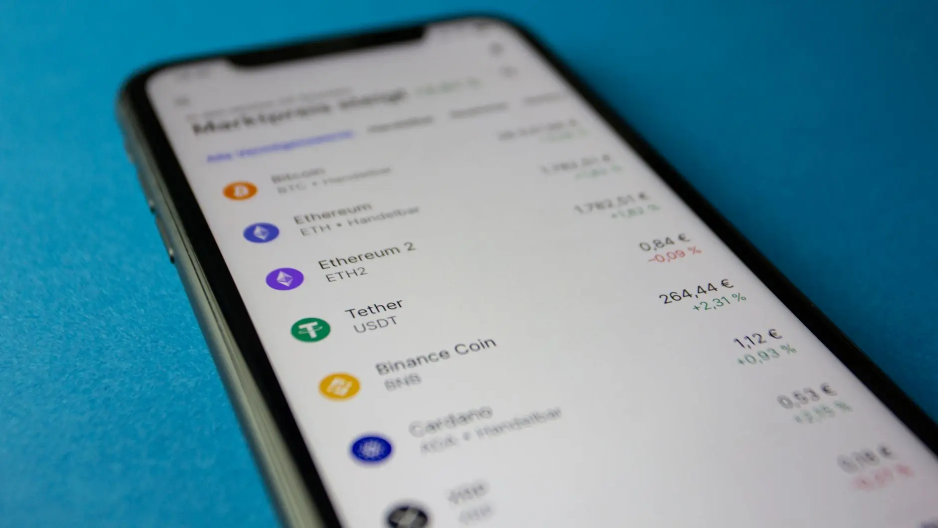 Close-up of a smartphone displaying cryptocurrency prices and market data.