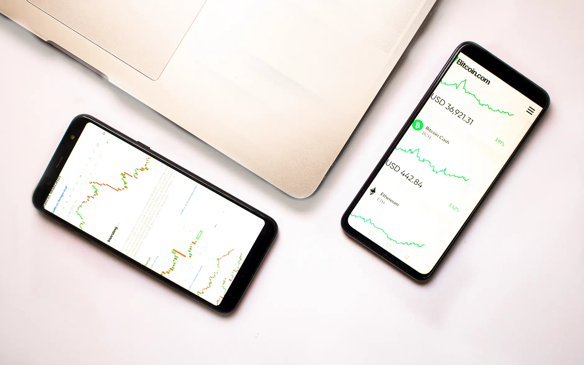 Smartphones displaying cryptocurrency charts, including Ethereum and Bitcoin information.