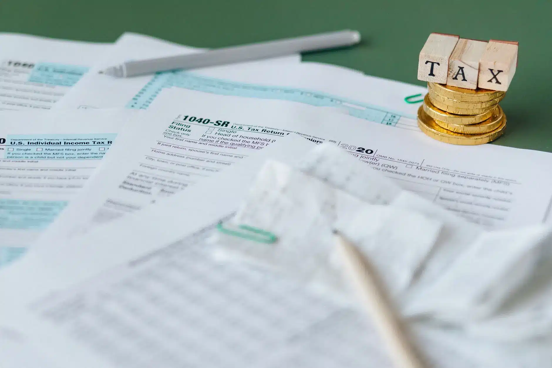 Tax documents and coins with letters spelling 'TAX' for finance regulation concept.
