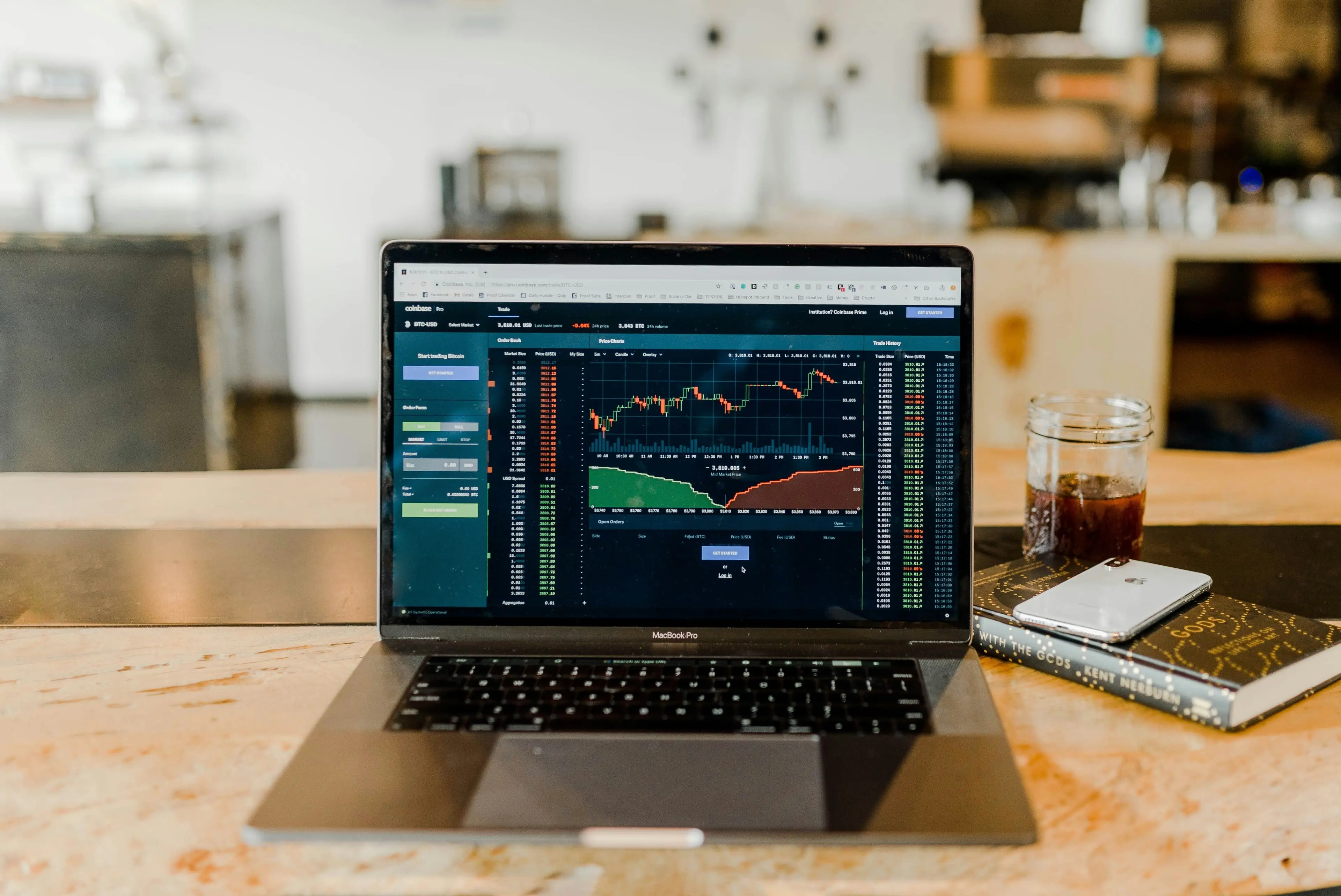 Laptop displaying cryptocurrency trading interface with colorful charts and data.