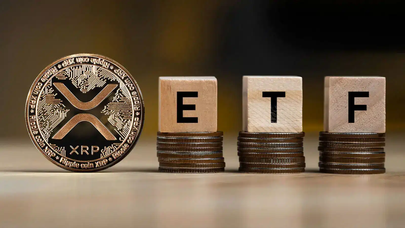 XRP cryptocurrency coin next to wooden blocks spelling ETF on stacks of coins.