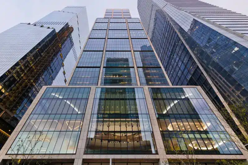 Low-angle view of the BlackRock headquarters skyscraper and surrounding glass buildings in New York City