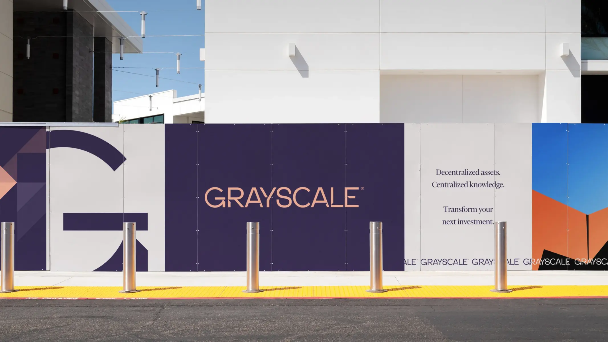 Exterior view of Grayscale Investments building featuring large brand signage on a white and purple wall.