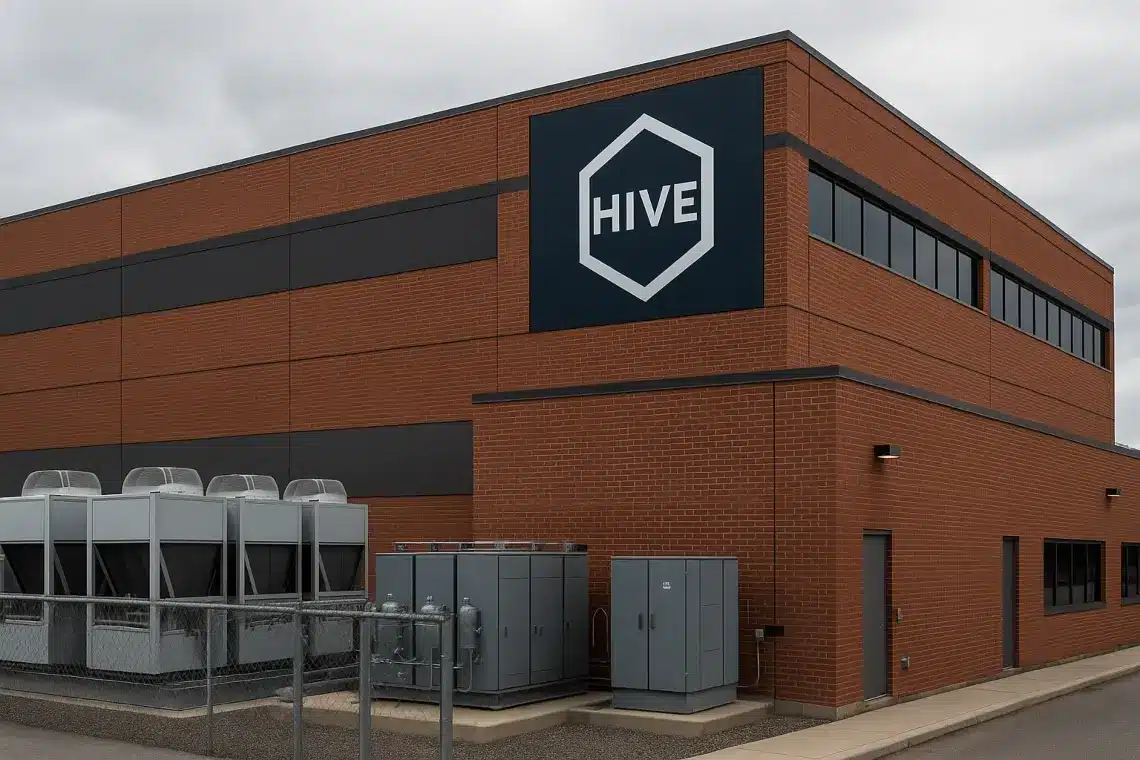 Exterior view of a red brick HIVE Digital Technologies data center building with cooling equipment in the foreground.