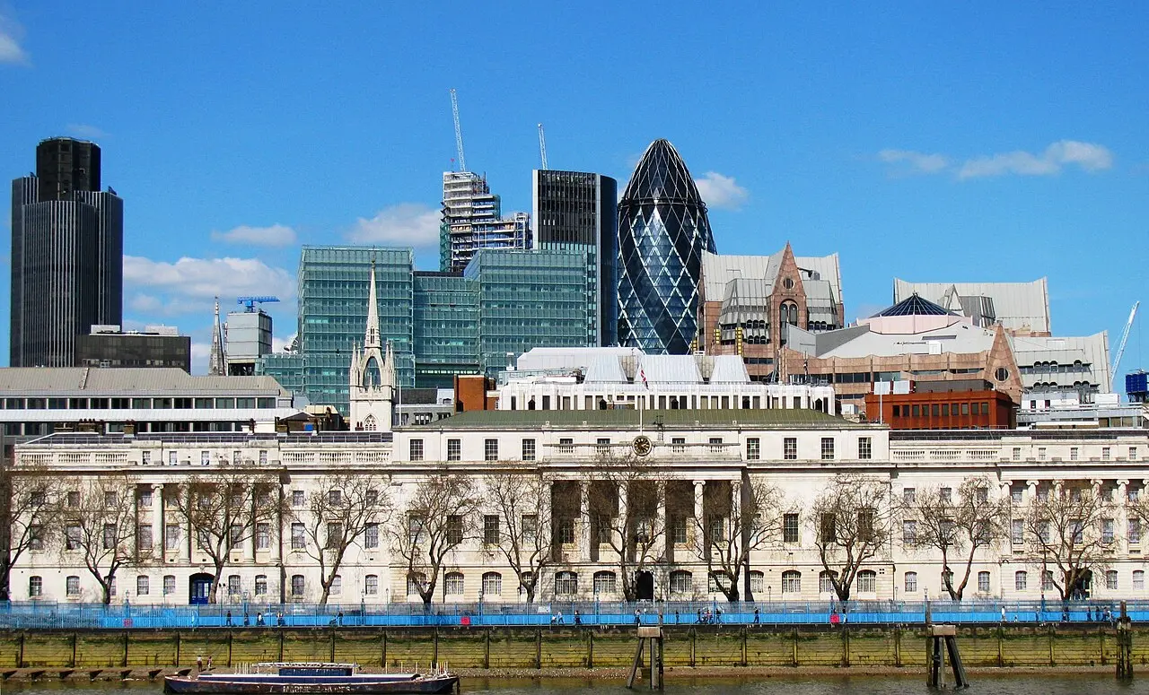 The white facade of the HM Revenue and Customs building in London with the City skyline in the background