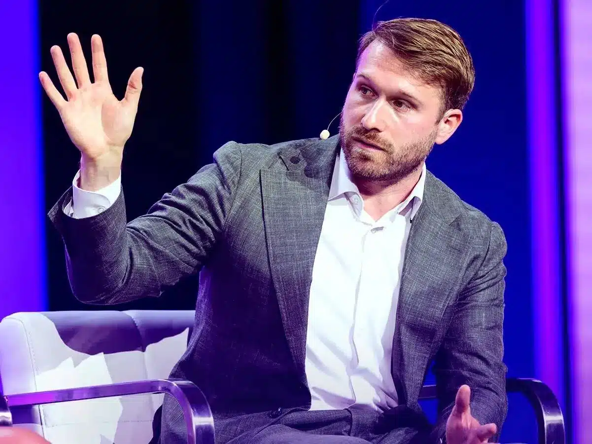 James Seyffart speaking while gesturing with his hand during a panel discussion
