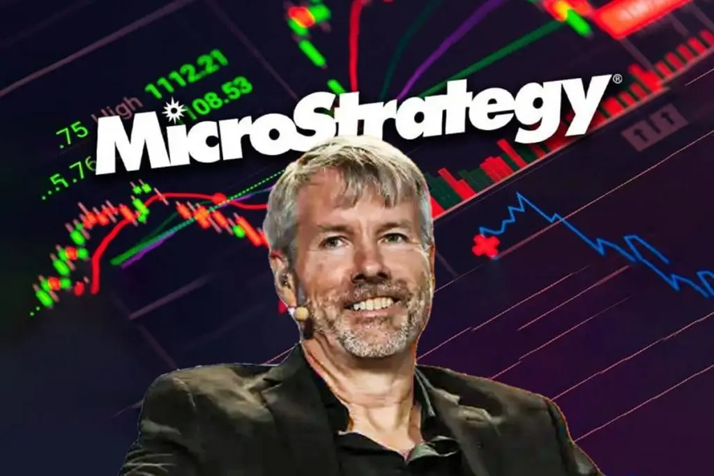 Michael Saylor smiling in front of a MicroStrategy logo and financial stock charts