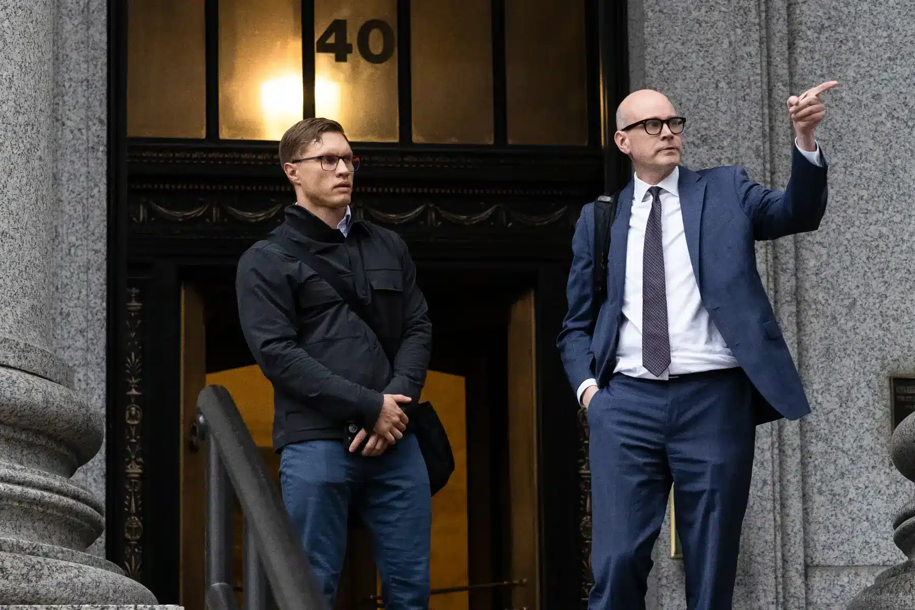 Roman Storm and his lawyer standing outside a courthouse entrance.