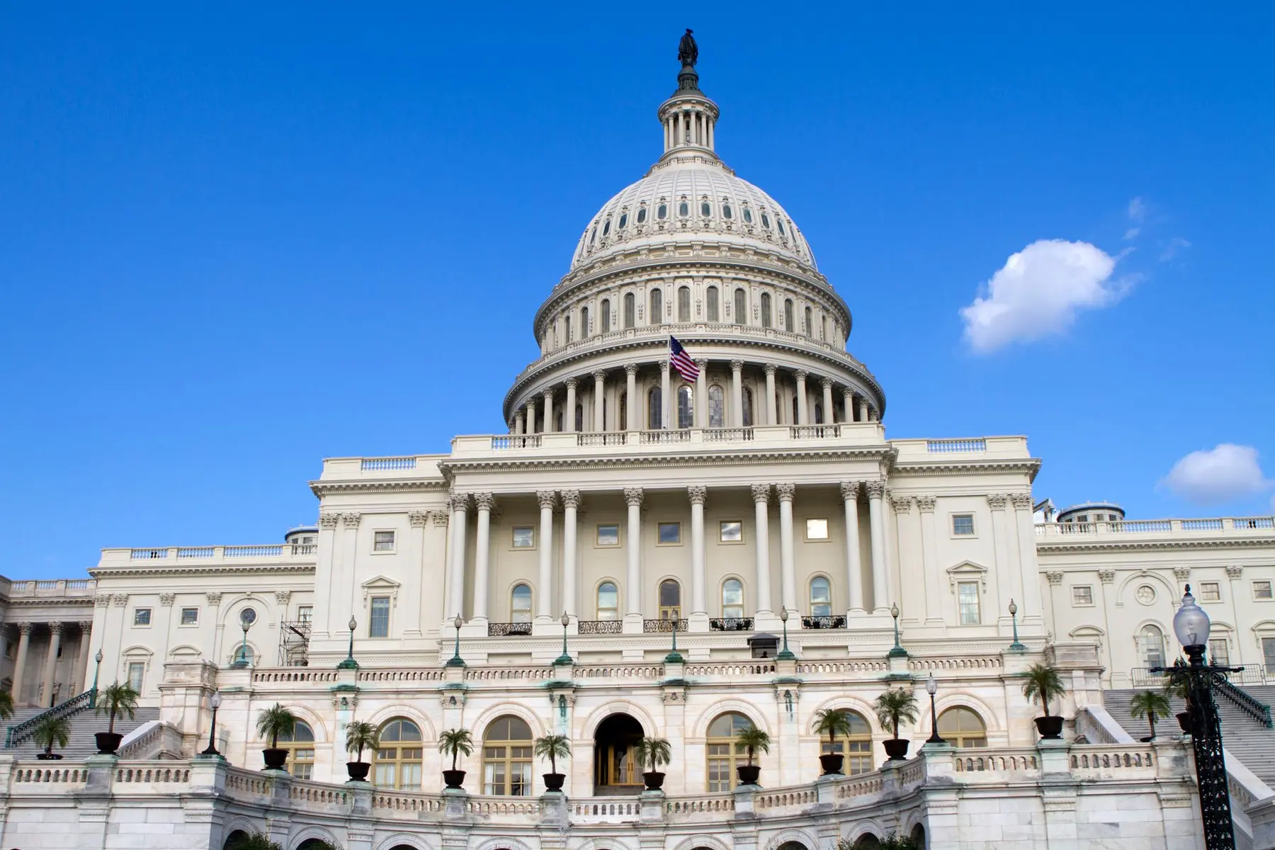 Front view of the US Capitol building in Washington DC with its white dome under a clear blue sky